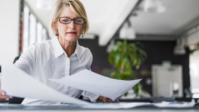 Businesswoman examining documents at desk