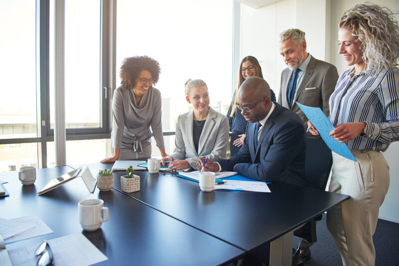 Diverse group of executives working together around a boardroom table