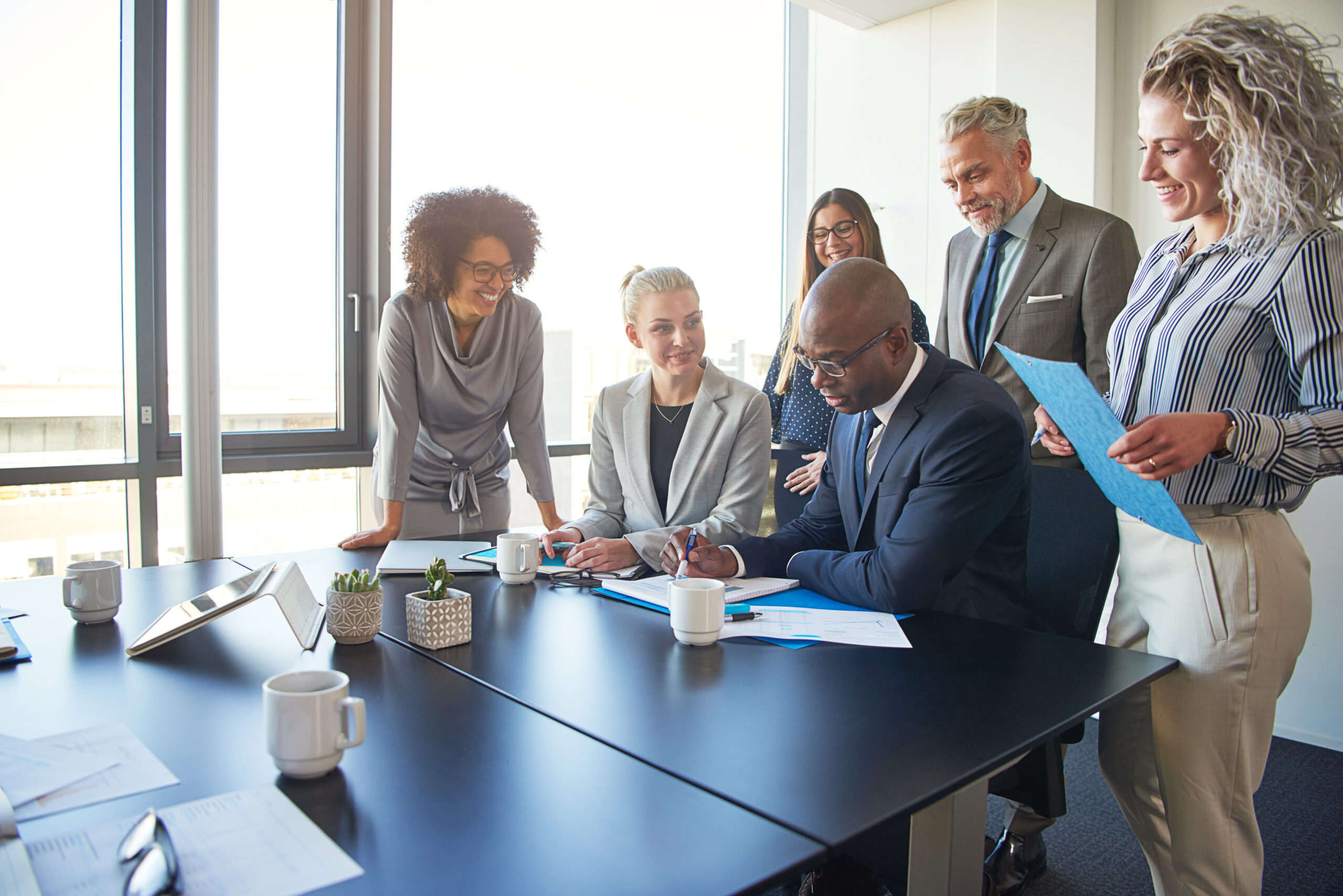 Diverse group of executives working together around a boardroom table