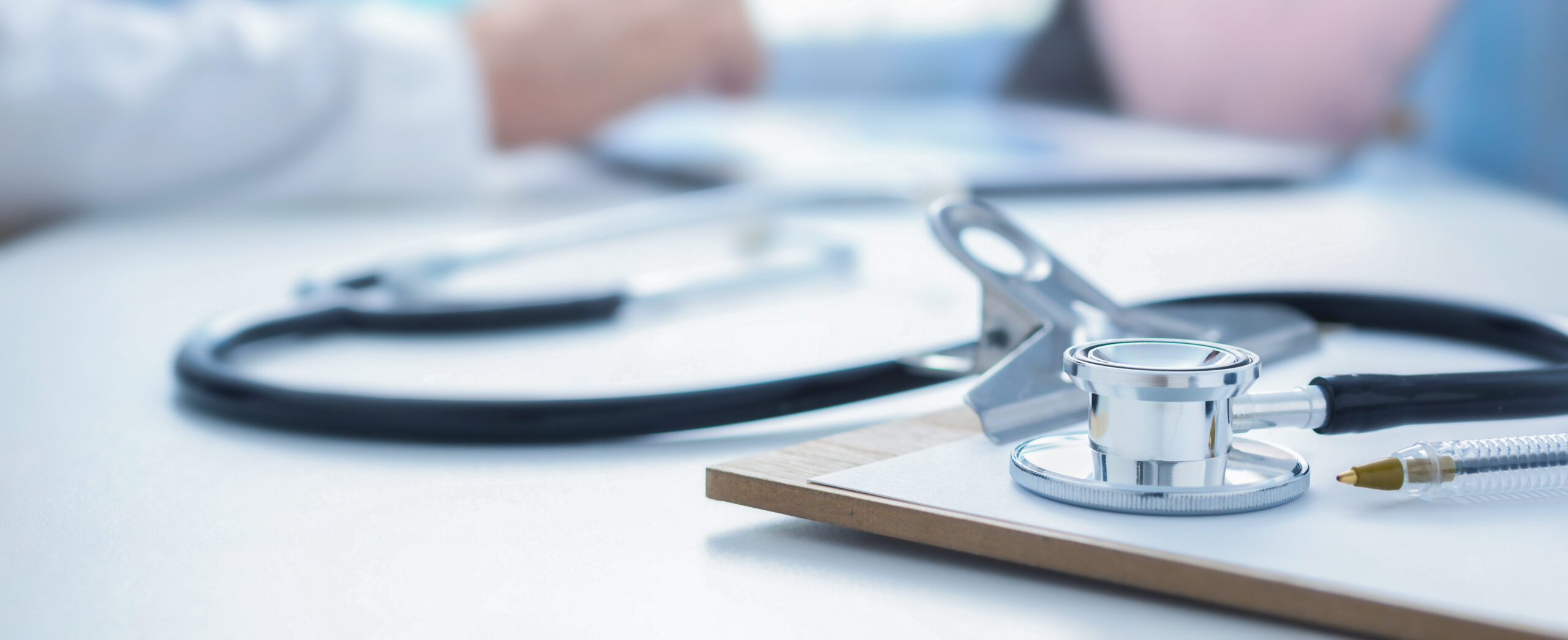 Stethoscope and clip board on doctor workplace close up