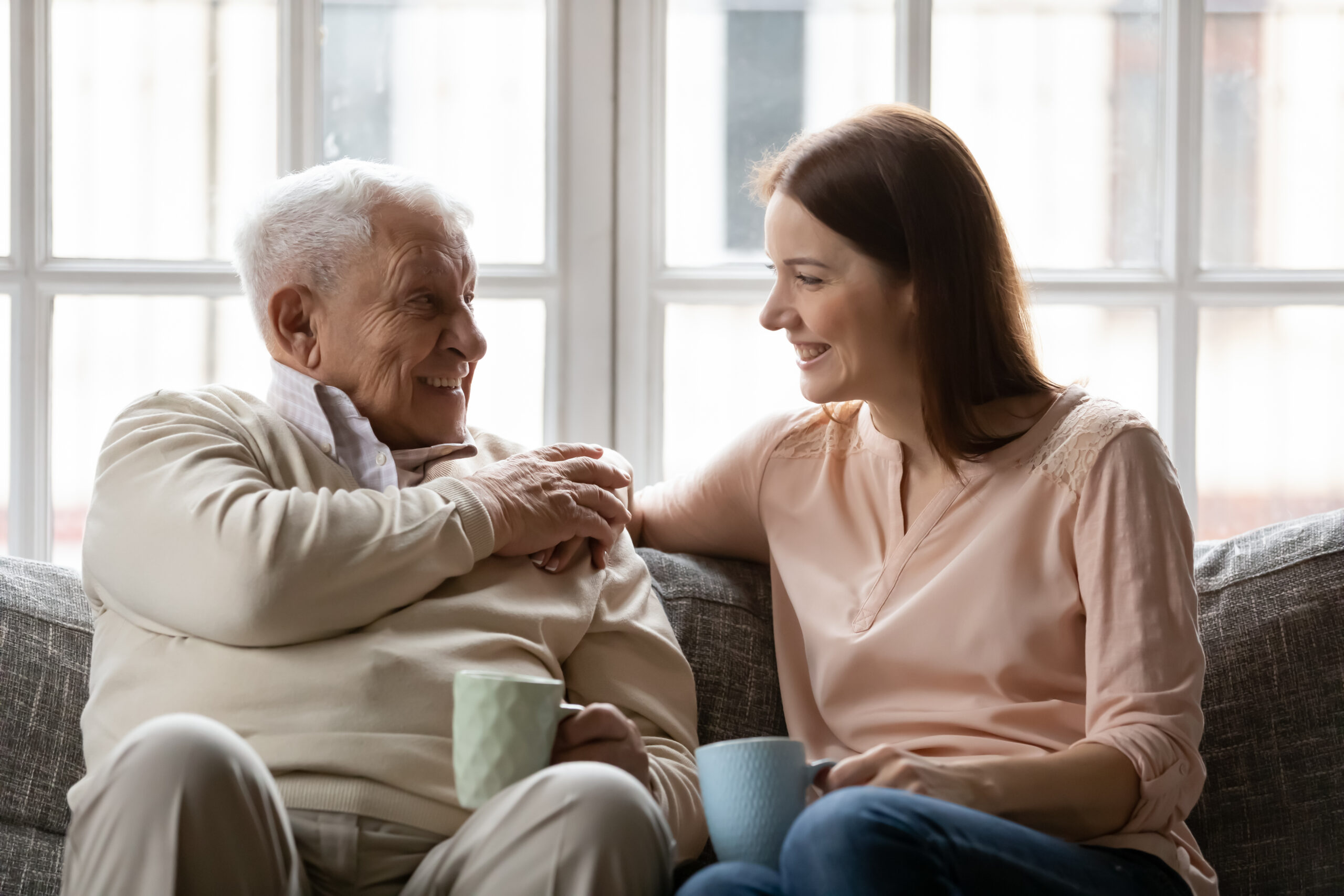 Elderly father enjoy conversation with daughter for cup of tea