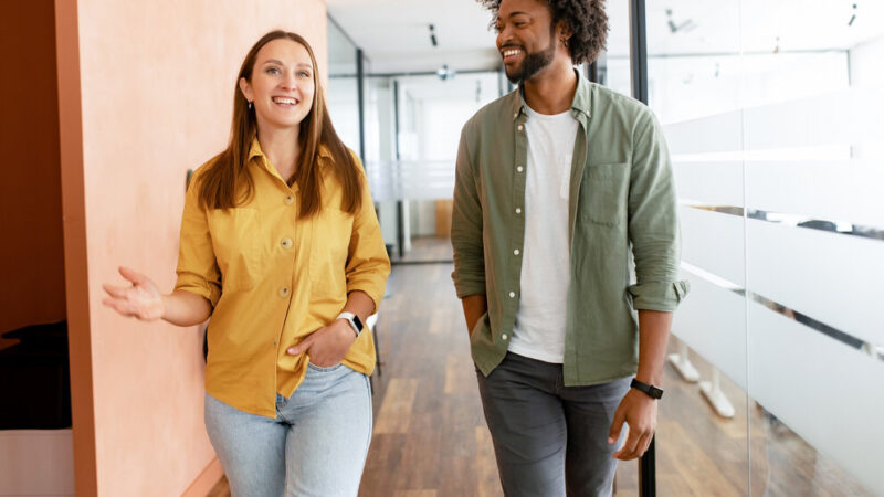 Couple of business people discussing tasks walking in the office hall