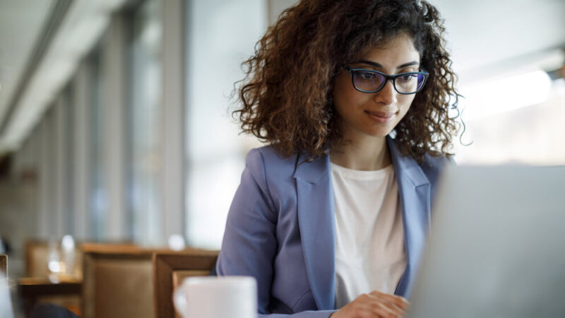 Businesswoman working on laptop at hotel cafe