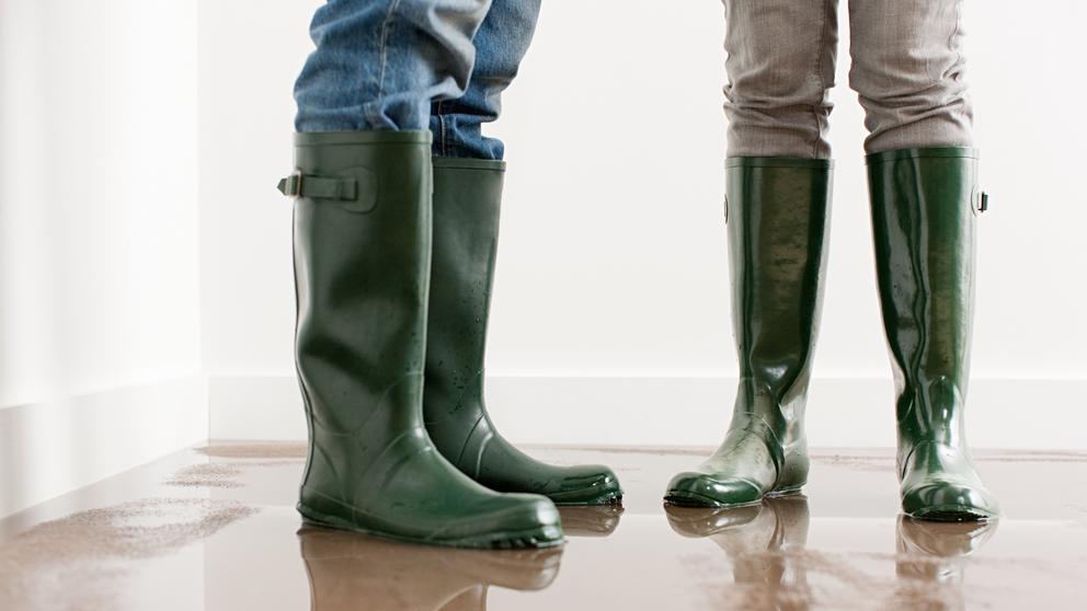 Young couple in wellington boots on flooded floor