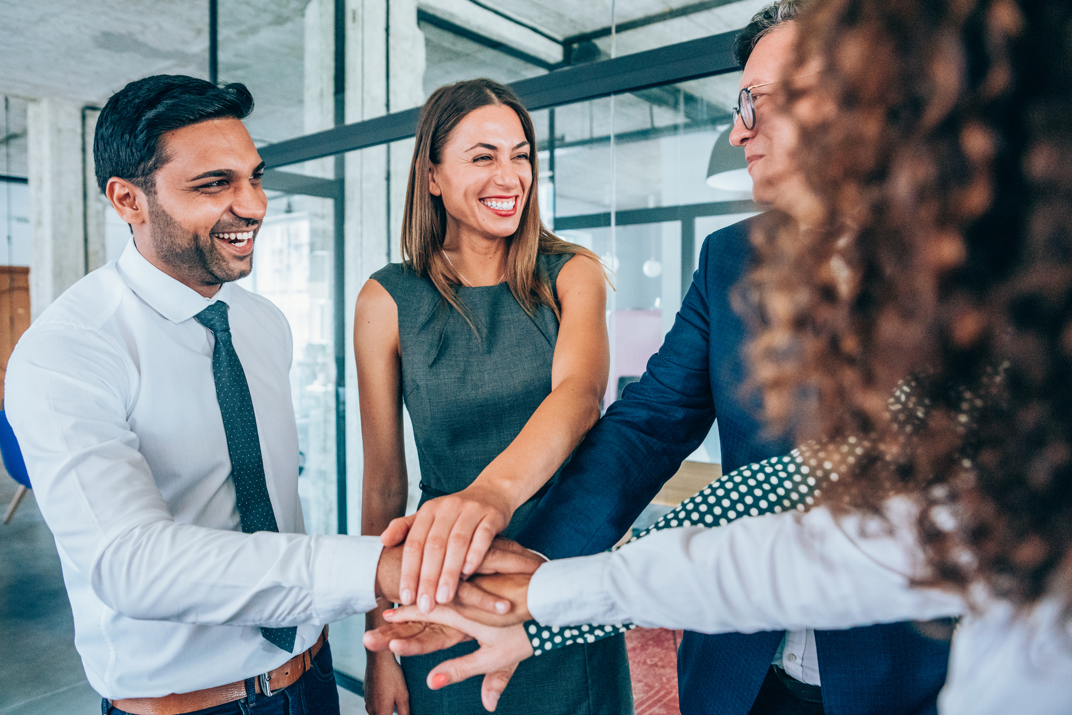 Business people stacking hands in conference room