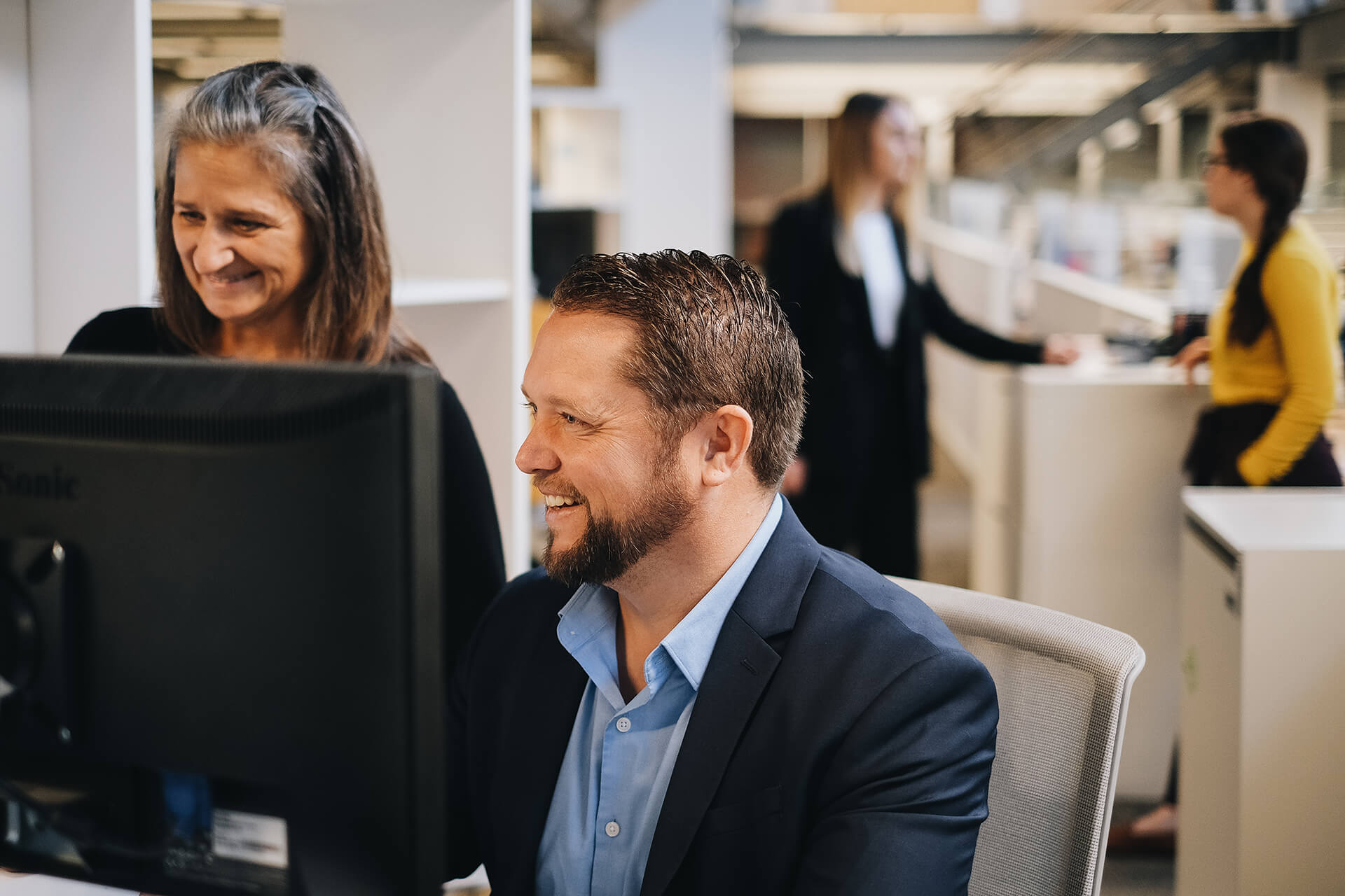 Smiling Man And Woman Looking At Computer
